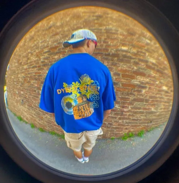 Foto a occhio di pesce di un ragazzo di spalle con la t-shirt Dyelit.