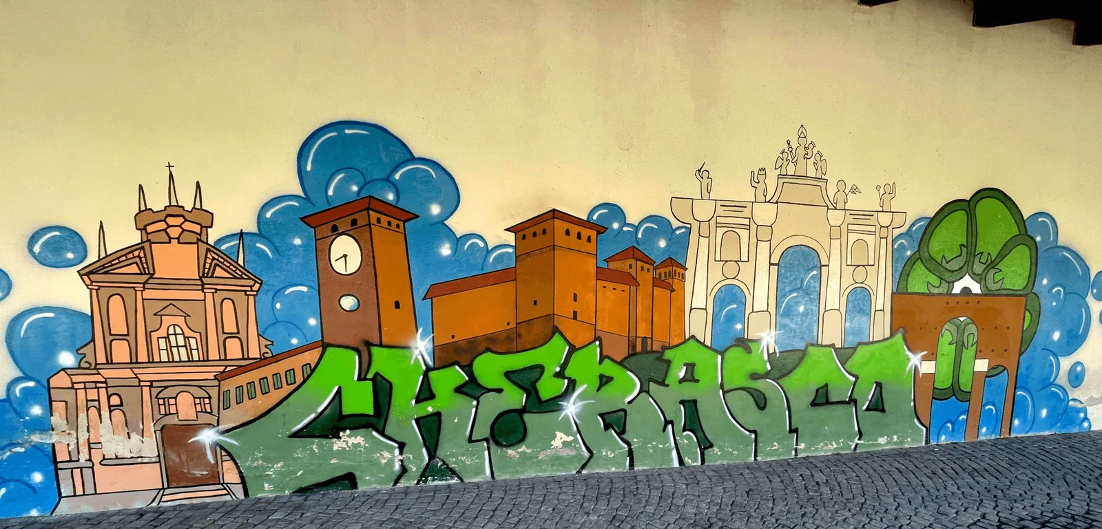 Bozzetto del murale di Cherasco: lo skyline dei monumenti della città in arancione e avorio su cielo azzurro con nuvole, e la scritta CHERASCO in lettere verdi bombate.