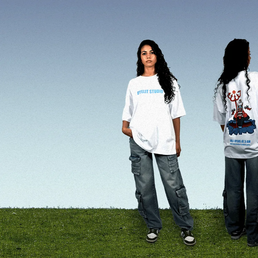 Due modelle su un prato, di fronte e di spalle, con la t-shirt bianca Dyelit Studio.